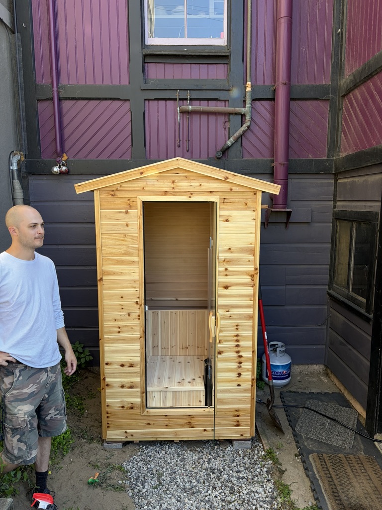 Outdoor steam sauna installation beside SF home with cedar siding