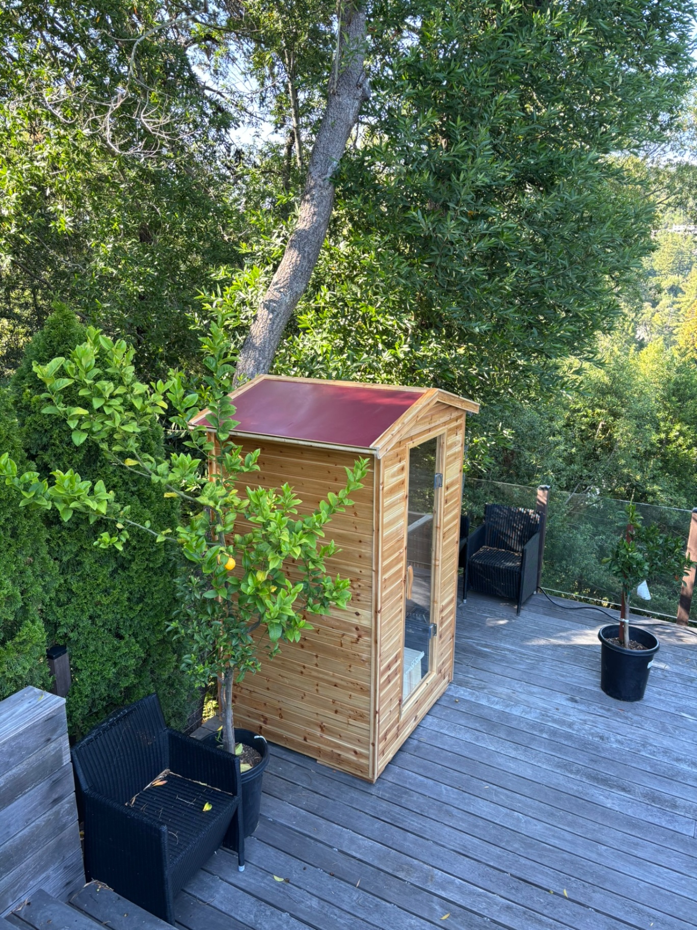Outdoor steam sauna with red roof on Bay Area deck with treetop views